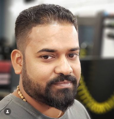 Headshot of a man with a beard and short hair, looking slightly to the side.