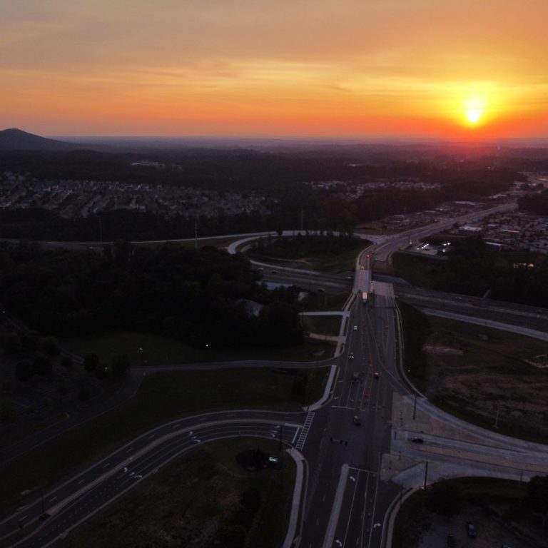 Aerial view of a highway 400 intersection  exit 18 at sunset with a mountainous backdrop on browns bridge road.