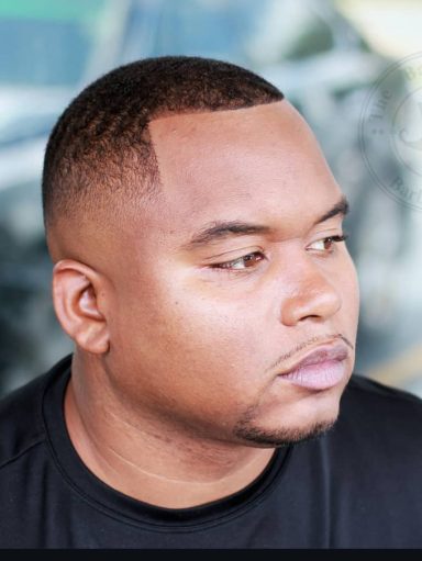 Close-up of a man with a short haircut, looking thoughtfully to the side.